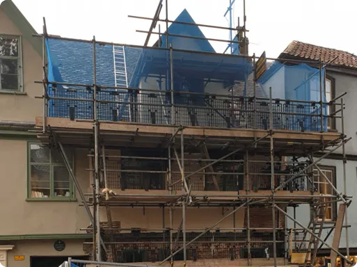 An exterior shot of a building with scaffolding erected on the outside